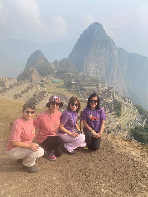 Group of women sitting with Machu Picchu in the background.