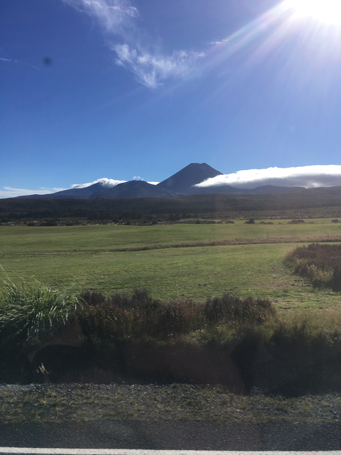 A mountain view with green fields and clear skies.