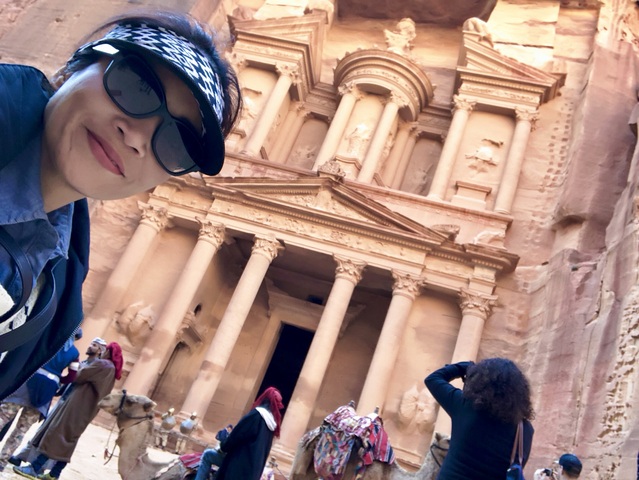       Woman taking a selfie at Petra's iconic rock face.
  