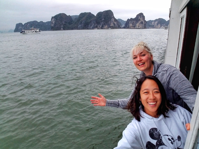 Two women on a boat with a water landscape background.