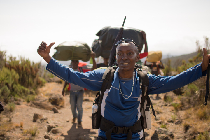       Portrait of a hiker with others walking in the background.
  