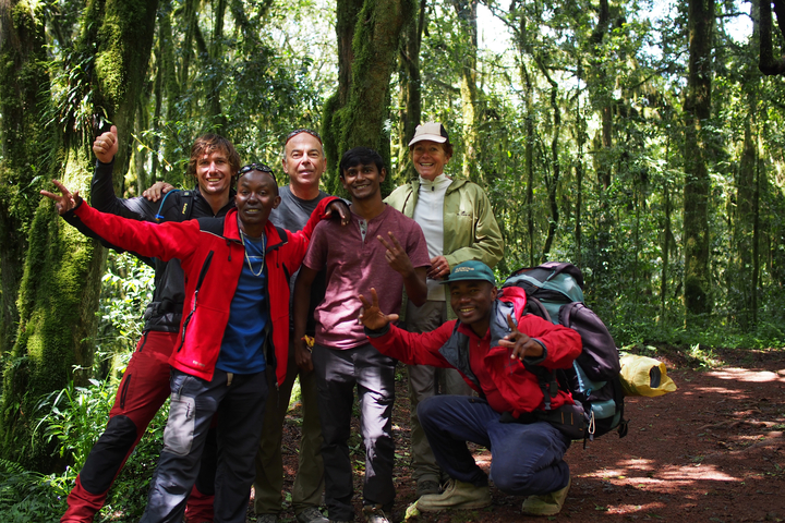       Group of people posing in a lush forest.
  