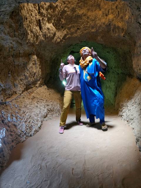 People in traditional clothing inside a cave.