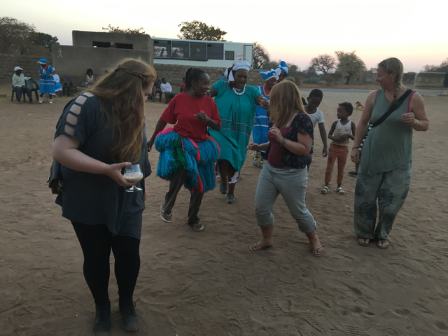       Tourists dancing with locals in a cultural exchange.
  