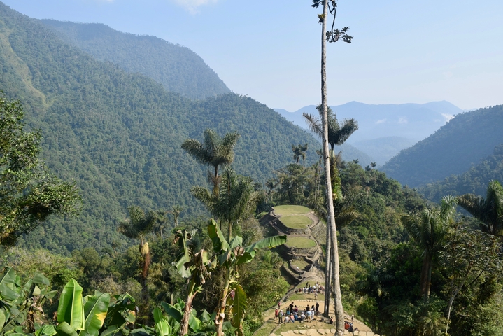 Panoramic view of jungle-clad hills with stone terraces.