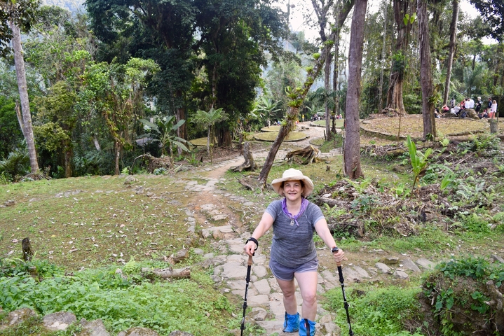       Woman enthusiastically hiking on a forest trail.
  