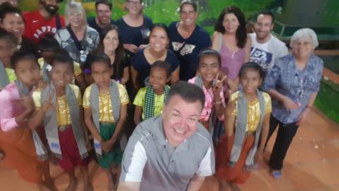       Group with children in colorful clothing, possibly in a cultural setting.
  