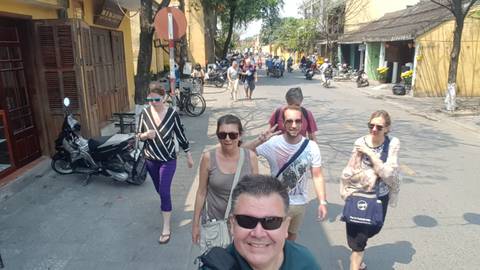       Group walking through a busy street in a cultural setting.
  