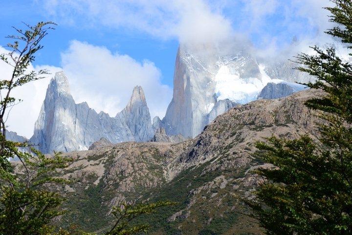       Mountainous terrain with snow-covered peaks and trees.
  
