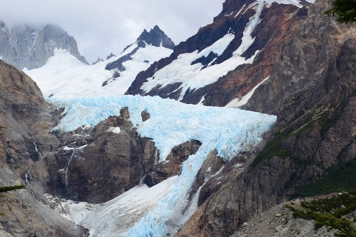       River flowing through a mountainous area with snow.
  