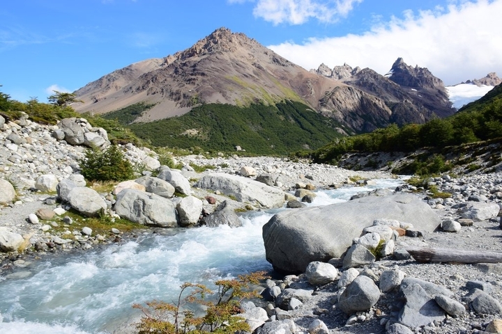 River flowing through rugged terrain with distant mountains.