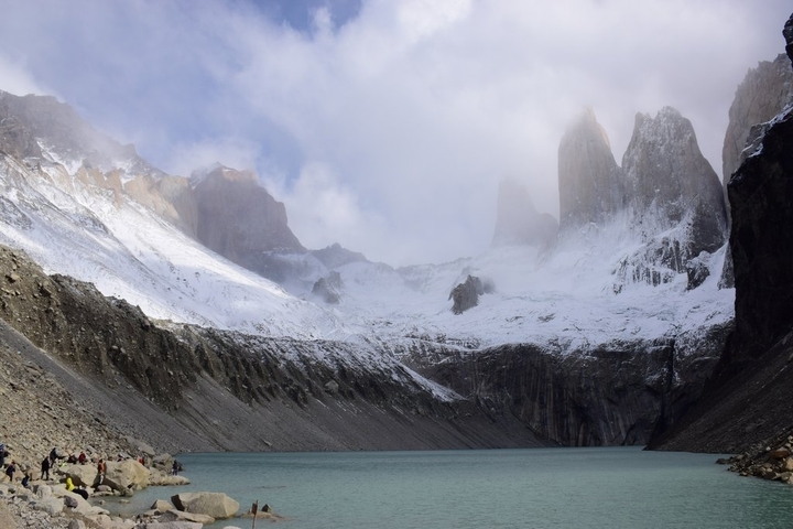 Mountain valley with snowy peaks and a turquoise lake.