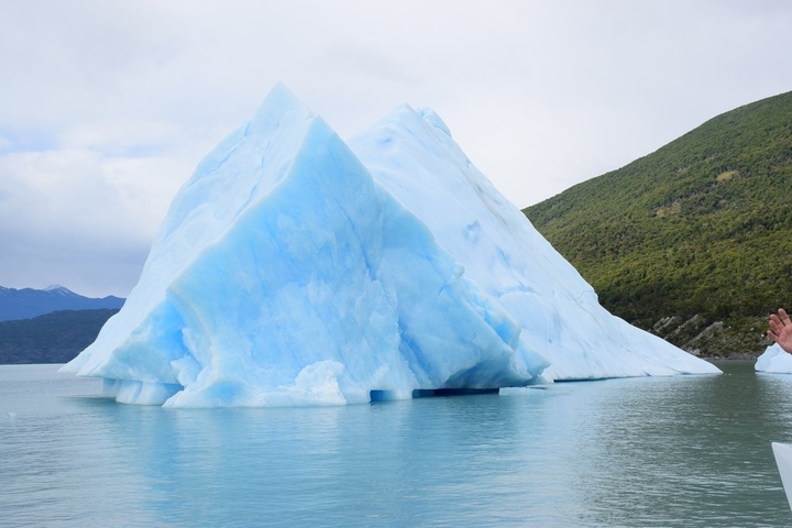       Large icebergs floating on a serene lake.
  
