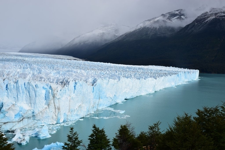       Plains with a large glacier edge meeting a lake.
  