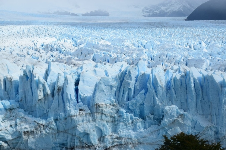       Jagged terrain of icy landscape with deep blue hues.
  