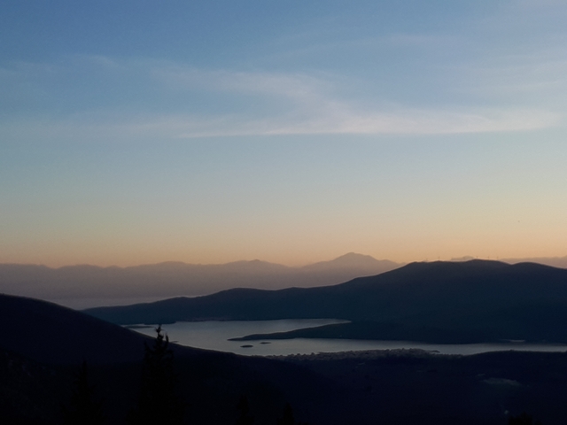 Twilight landscape view with mountains and a lake.