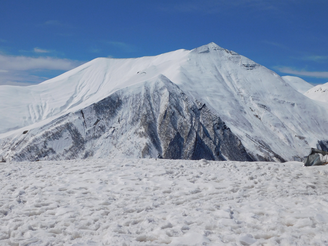 Snow-covered mountain landscape under clear blue skies.
