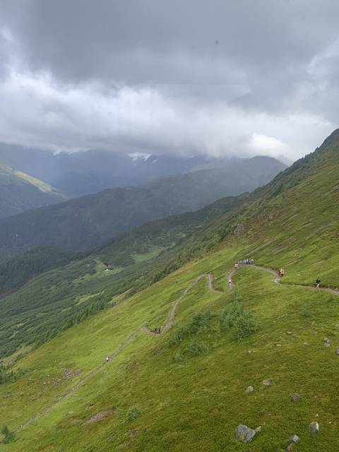 Trail through a lush, green mountainous area.
