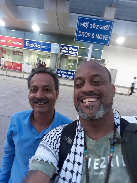       A selfie with another person in front of a building.
  