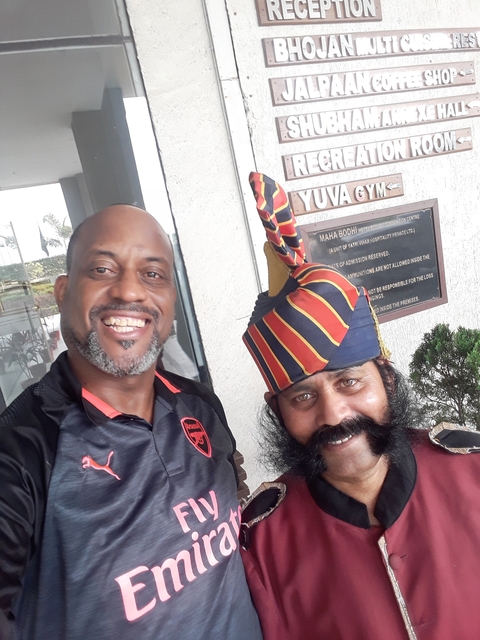       A man with a security guard in traditional uniform.
  