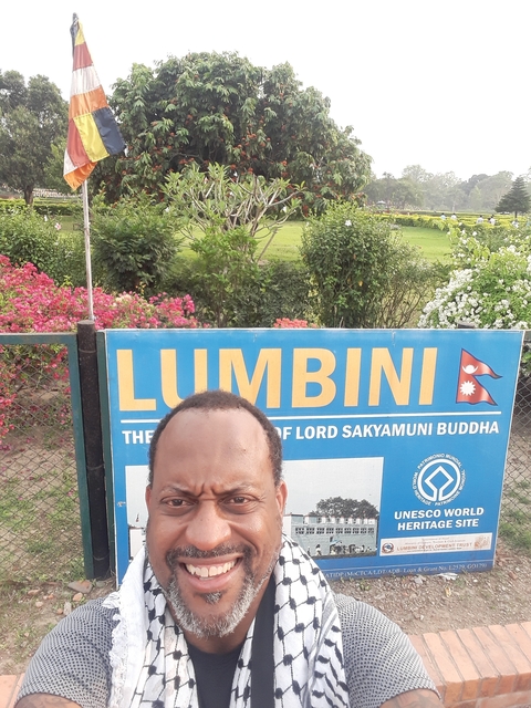       A selfie in front of a Lumbini sign.
  