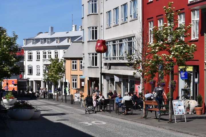       Street scene with colorful buildings and outdoor diners.
  