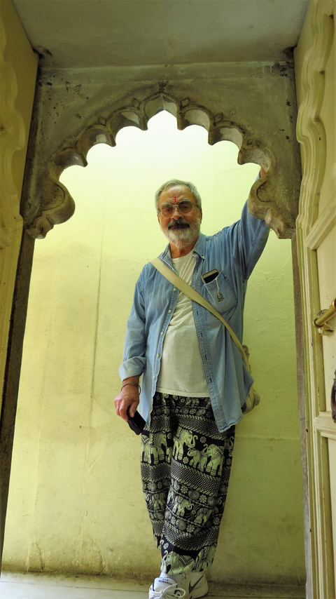 A person standing in a historic building's arched entrance.