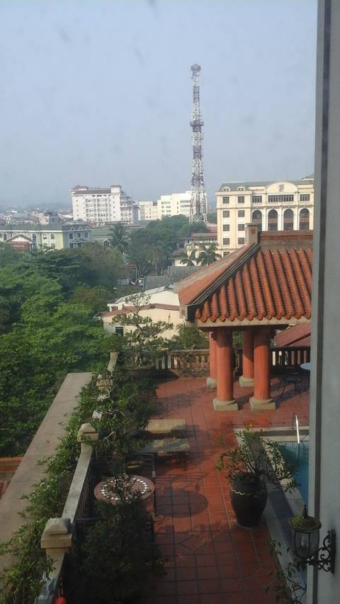       View of rooftops and a distant tower from a window.
  