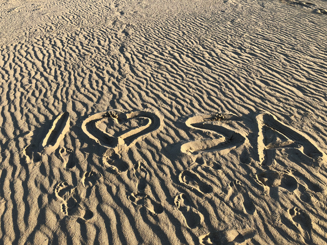 Sandy surface with 'I ♥ SA' written in the sand.