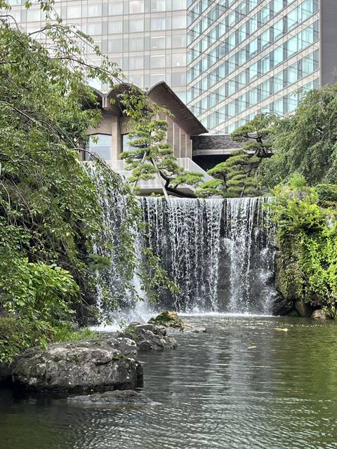 A waterfall flowing alongside a modern building.