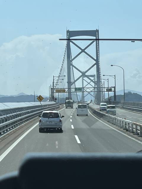       A bridge with vehicles passing over it against a blue sky.
  