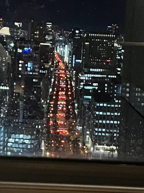 A cityscape at night with bright lights and traffic.