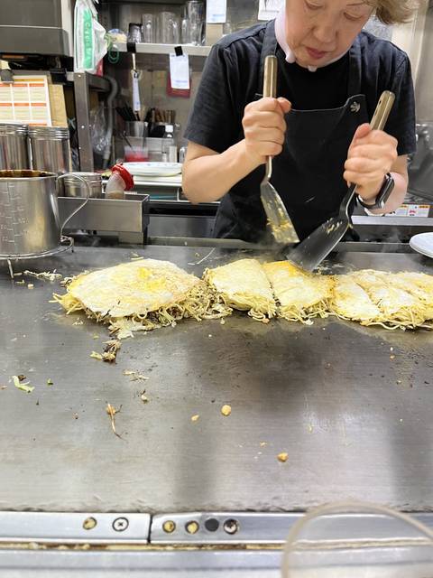       A chef preparing food on a grill at a restaurant.
  