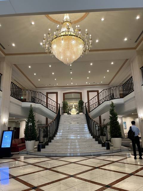       A grand staircase with chandeliers in a luxury hotel.
  