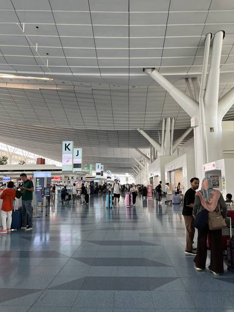       People in a spacious airport terminal.
  