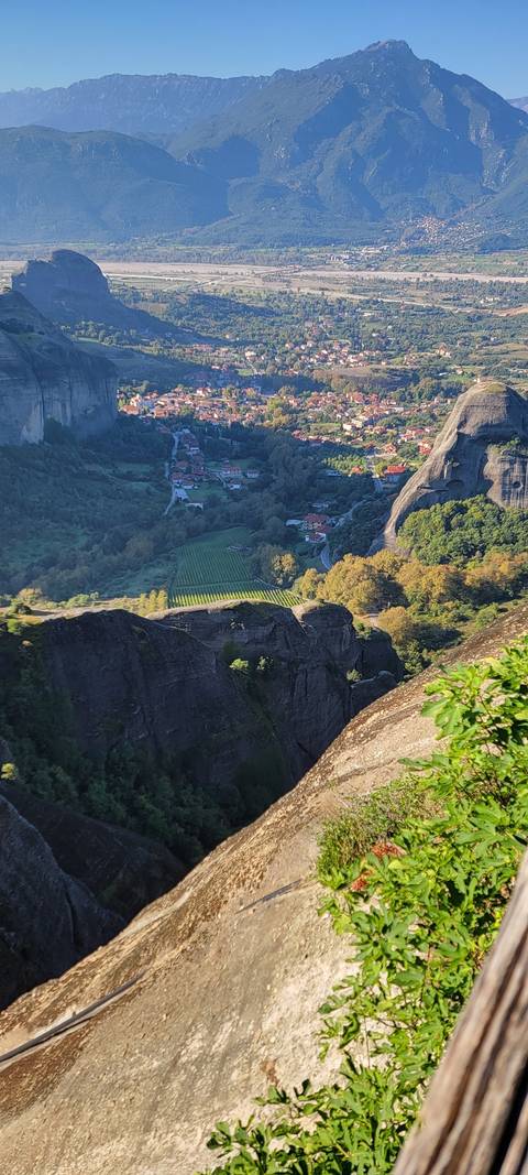       Aerial view of a valley with rooftops and fields.
  
