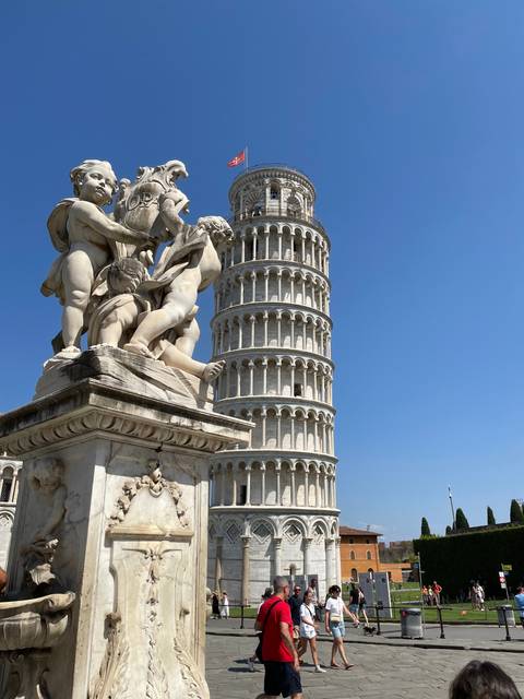 Leaning Tower of Pisa with nearby sculptures.