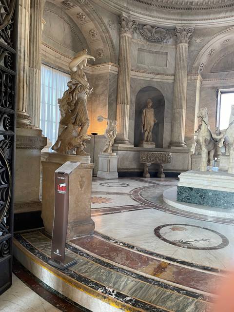Museum interior with sculptures and marble floors.