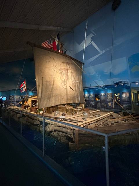       Museum interior with a ship and flags.
  