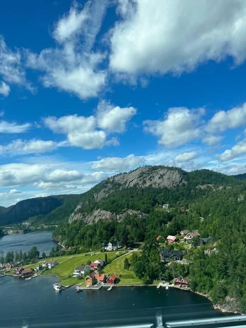       Scenic view of a town by the water with mountains in the background.
  
