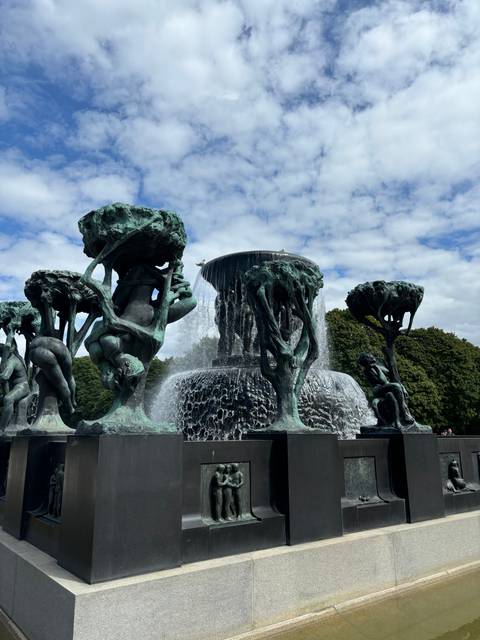       Sculptures by a cascading waterfall.
  
