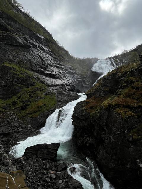       Tall waterfall cascading down a rocky cliff.
  