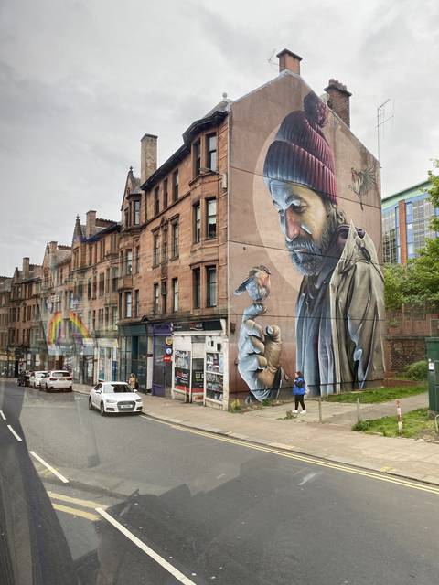       Street view with large mural on a building.
  