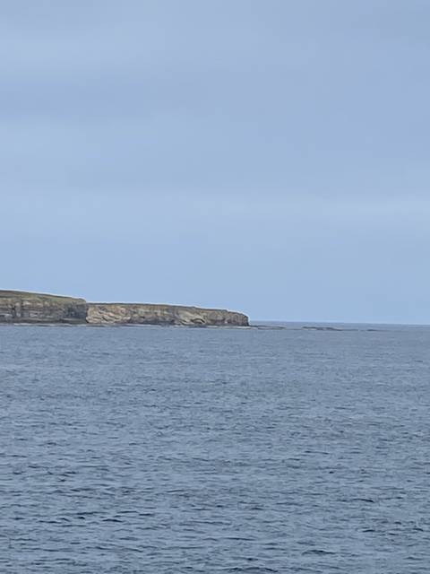       Cliffside and ocean view under a blue sky.
  