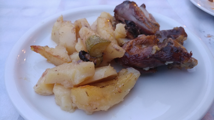 Plate of dish with potatoes and meat.