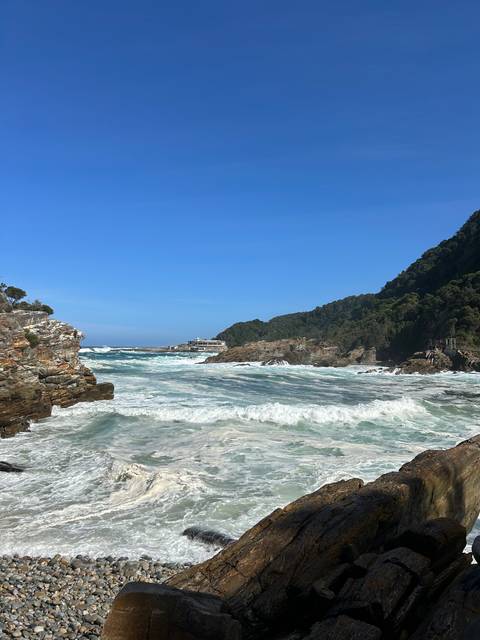       Ocean waves crashing against rocks with viewing platforms.
  