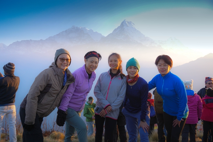       A group of people with snowy mountains in the background.
  