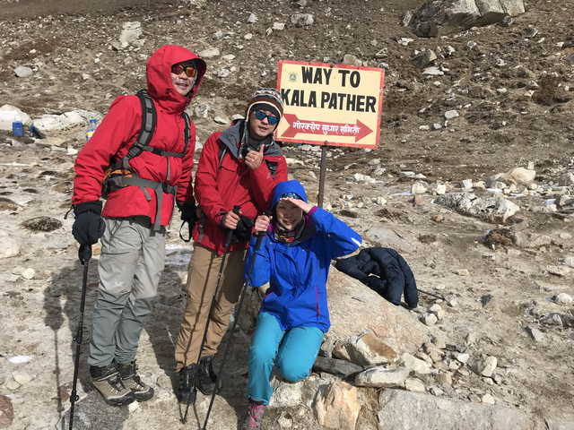 Hikers in Nepal with a sign pointing to Kala Patthar