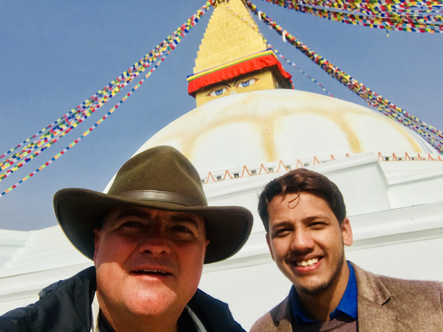 Two men taking a selfie in front of a stupa