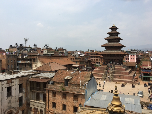 Temple with people climbing stairs in a historic city.